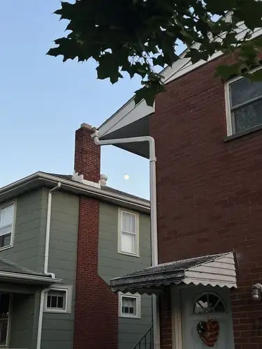 Moonlit evening over suburban rooftops.